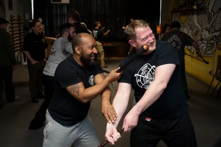John Cheatwood III (left), 45, of Pittsburgh, practices fighting techniques with Ross Lungren, 41, of Pittsburgh, during a Combat Shillelagh class at Pittsburgh Bujinkan Dojo.