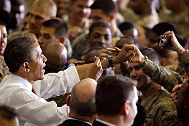 President Obama greets U.S. troops at the Bagram base. Earlier, he signed a pact with the Afghan president to cover the continued training and counterterror role of U.S. forces after a final exit of combat troops in 2014. CHARLES DHARAPAK / AP