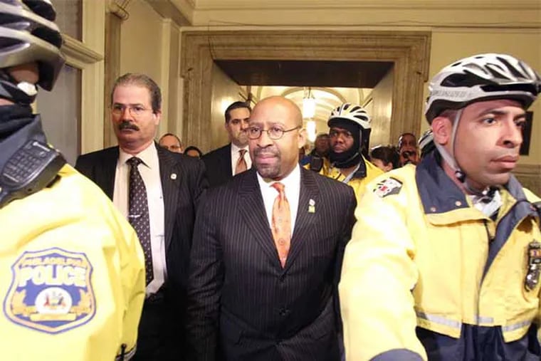 Mayor Nutter is escorted by police after he was unable to to deliver his budget address to City Council.  He was unable to do so because of the disruption caused by protesters. (Charles Fox / Staff Photographer)