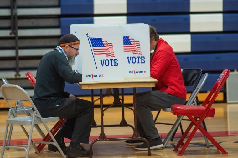 People cast their ballots while voting at the local polling place at Central Bucks East High School in Buckingham.