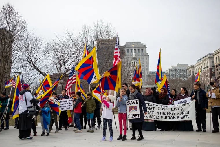 A crowd holds Tibetan flags at Independence Mall in front of Independence Hall Sunday as part of a ceremony and march to mark the 60th anniversaries of the Tibetan Uprising and the Dalai Lama's flight into exile.
