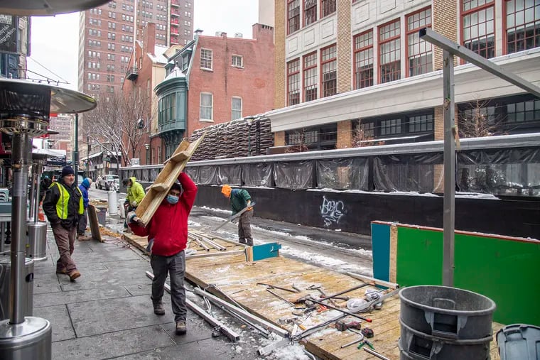 Workers removed outdoor dining pods along 13th Street in Center City in January 2022. The eating areas became popular during the panademic as a way to social distance but also drew complaints because of blocked sidewalks and parking spaces.