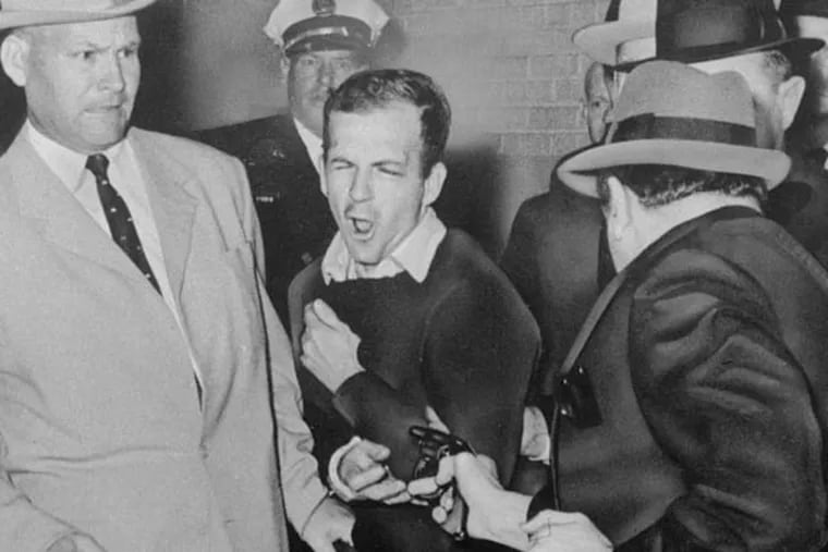 Lee Harvey Oswald, accused assassin of President John F. Kennedy, reacts as Dallas night club owner Jack Ruby, foreground, shoots at him from point blank range in a corridor of Dallas police headquarters, November 24, 1963.  Plainclothesman at left is Jim A. Leavelle. (AP Photo/Dallas Times-Herald, Bob Jackson)
