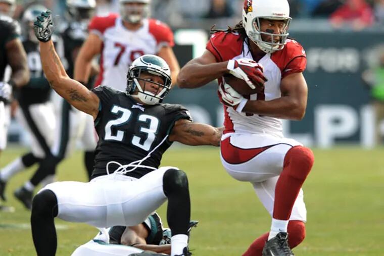 Cardinals receiver Larry Fitzgerald bounces off the attempted tackle by Eagles defensive backs Patrick Chung (23) and Brandon Fletcher (on ground) to score a touchdown. (Clem Murray/Staff Photographer)