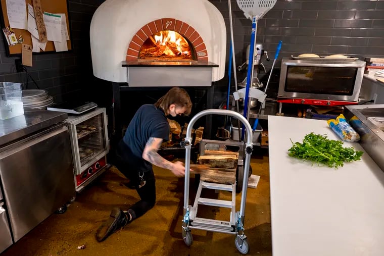 Eeva line cook Logan “Log” Paz supplies the wood oven with local wood for the night from Phil's Firewood at the Kensington bakery/restaurant Thursday, Jan. 12, 2023. Eeva's wood-fired oven is a huge part of its kitchen, and Paz says he is the person, “in charge of the wood.”