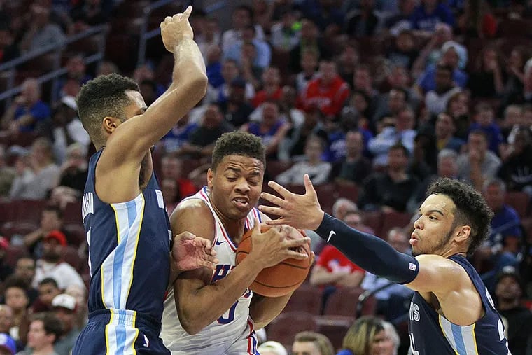 Markelle Fultz (center) struggles to drive between the Grizzlies’ Andrew Harrison (left) and Dillon Brooks.