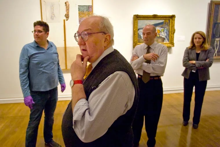 Joseph Rishel checking whether a Cézanne work hangs properly in a 2009 exhibit. Asked about revisiting the artist, he said: “Cézanne is like a fine ham. You can keep slicing and slicing. …”