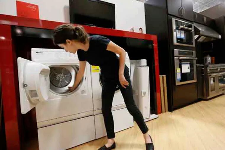 In this photo taken Friday, Apr. 26, 2013, Miele Account Manager Natasha Feldman showcases Miele washer and dryer energy efficient appliances at the Pacific Sales at the Best Buy store in Glendale, Calif. The Commerce Department reports on business orders for durable goods in April on Friday, May 24, 2013. (AP Photo/Damian Dovarganes)