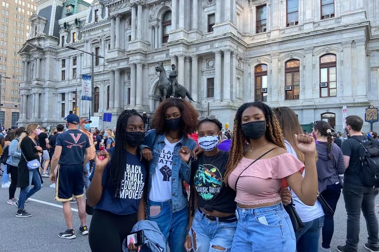 Temple students (left to right) Zayna McNeil, 21, Lauren Jackson, 18, Merissa Chase, 20, and Rachelle Small, 20,  pose in front of City Hall, fists up. It is “amazing to see myself represented in such a high power,” Jackson said, referring to Harris. “Not only as Black people but as a woman and minority in the office," Small said, “this is history being made.”