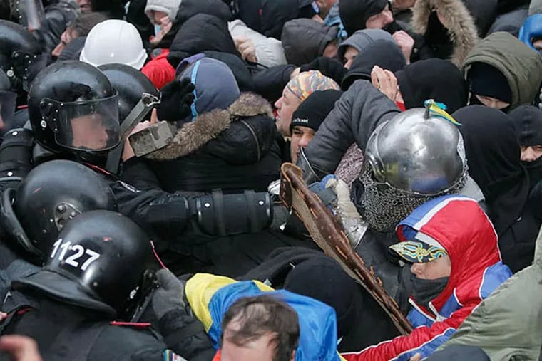 Protesters clash with police outside the presidential office in Kiev, Ukraine, on Sunday. About 300,000 Ukrainians assailed the president's refusal to sign an agreement with the European Union. (AP photo)
