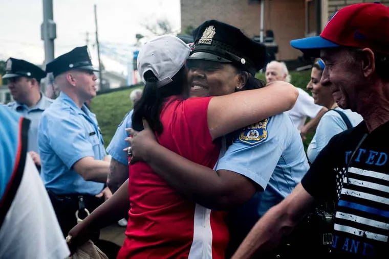 Officer Talibah Day gets a hug from Melissa Williams at a pro-cop rally at the Fifth District station in Roxborough.