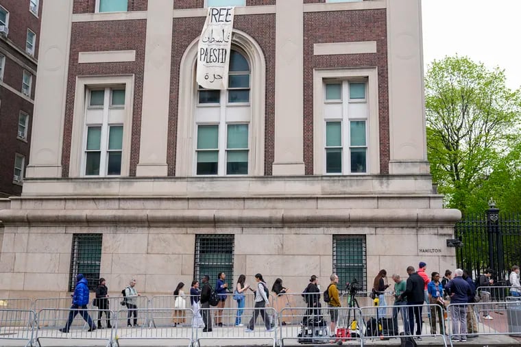 Students and staff line up outside Hamilton Hall at Columbia University Tuesday, where protesters have barricaded themselves inside.