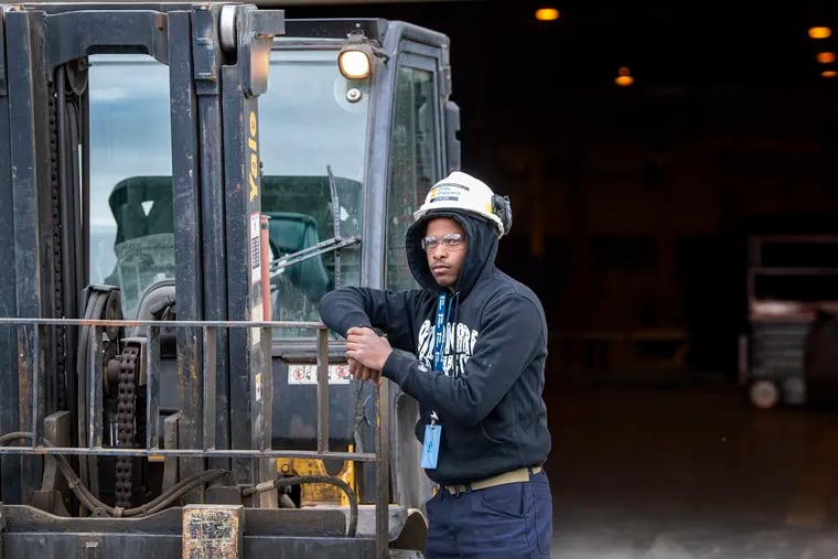 Muhammad Tumaini, newly hired, near his sheet metal transport work vehicle at Philly Shipyard. A workforce development program recently placed a group of new recruits in jobs as laborers at the shipyard.