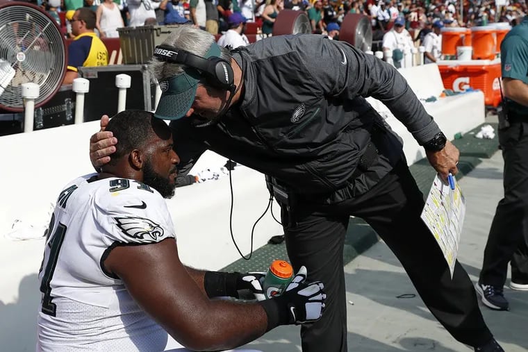 Philadelphia Eagles head coach Doug Pederson, right, speaks with defensive tackle Fletcher Cox in the final moments of an NFL football game against the Washington Redskins, Sunday, Sept. 10, 2017, in Landover, Md. Philadelphia won 30-17.