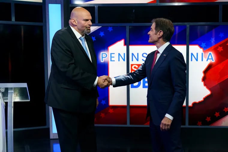 Lt. Gov. John Fetterman, the Democratic nominee for U.S. Senate, and Republican candidate Mehmet Oz shake hands prior to a debate in Harrisburg on Tuesday.