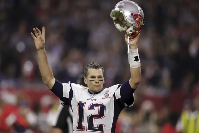 New England Patriots' quarterback Tom Brady raises his helmet after his team scores a game-winning overtime touchdown to beat the Atlanta Falcons 34-28 in NFL Super Bowl 51 in Houston on Sunday.