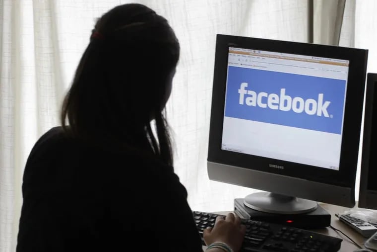 A girl looks at Facebook on her computer in Palo Alto, Calif., in a 2012 file photo. This weekend, Facebook banned the high-profile data firm Cambridge Analytica — paid more than $6 million by President Trump’s 2016 campaign — after a joint New York Times/Guardian probe revealed the improper harvesting of data from an estimated 50 million users of the platform.