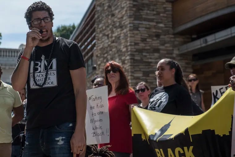 Ismael Jimenez, left, rallies Friday outside the Cinemark theater where police confronted him and his family.