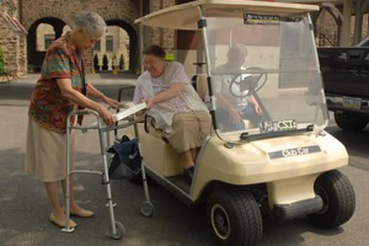 At the Sisters of the Blessed Sacrament campus in Bensalem, Sister Juliana helps Sister Therese board the new golf cart.