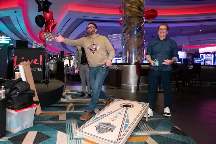 The Philadelphia Bell-Ringers will be a part of the newly founded league called Major League Cornhole. Bell-Ringers co-owner Zeb Campagna (left) and radio host and blogger Mike Missenelli play a game of cornhole at the team's signing announcement at Live! Casino in South Philadelphia on Friday.