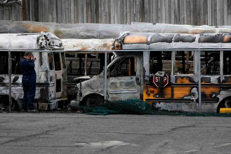 An investigator photographs burned buses Thursday at Bordentown Regional Middle School. A fire tore through Bordentown School District's bus yard early Thursday, damaging or destroying 11 buses and vans, a spokesman said. Authorities have not determined the cause of the blaze, and the district closed four of its five schools for the day. Classes resume Friday.