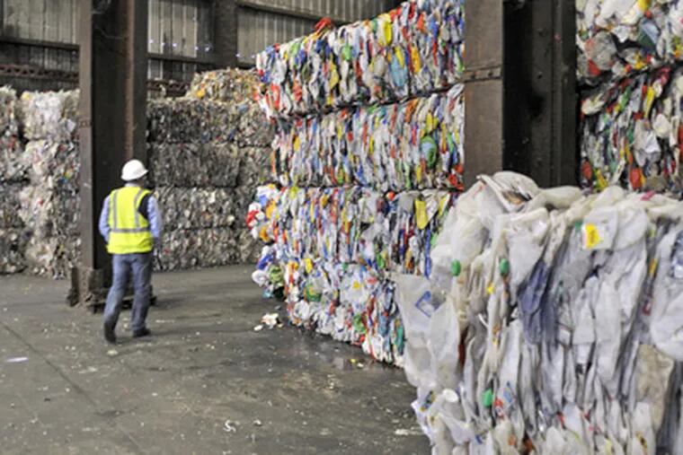 Michael McQuade of ReCommunity passes through bundles of sorted plastic at the company's Camden recycling plant. (Tom Gralish / Staff Photographer)