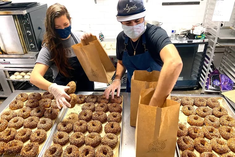 Alexandra and Jacob Cohen of Kismet Bagels wrangling their product into bags.