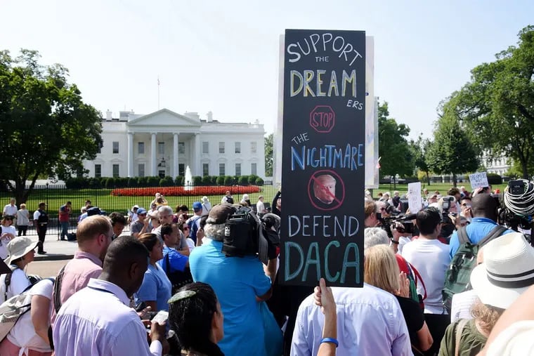Protesters hold up signs during a 2017 rally supporting Deferred Action for Childhood Arrivals, or DACA, outside the White House.
