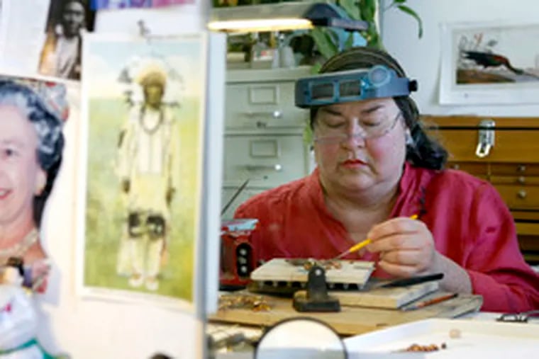 Jan Yager at work in her studio, where pictures - Queen Elizabeth II is in one - provide inspiration.