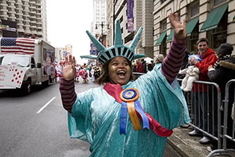 LaToya Lonon of Atlantic City entertains the crowd on South Broad Street dressed as the Statue of Liberty.