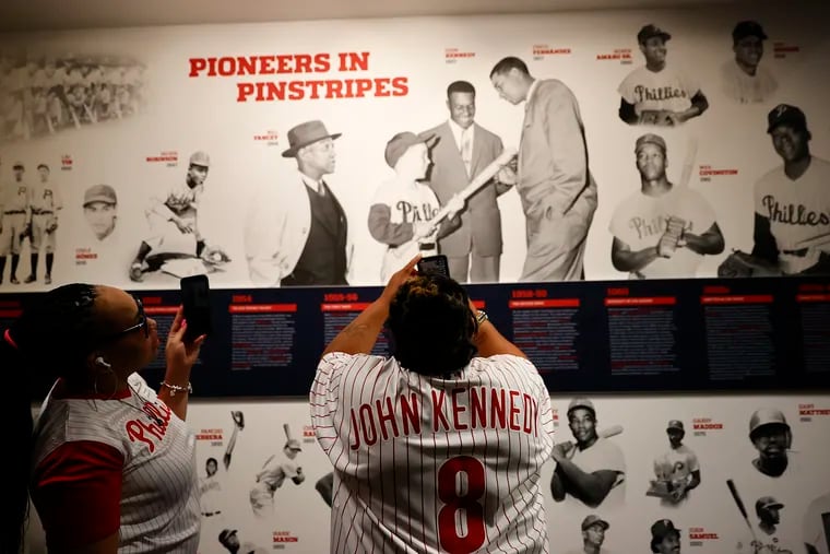 Family members of Phillies pioneer John Kennedy take photos of the new ‘Pioneers in Pinstripes’ display to families of the club’s first black and minority players on Jackie Robinson Day at the Hall of Fame Club at Citizens Bank Park.