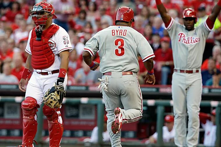 Marlon Byrd (3) scores on a double by Domonic Brown in the fourth inning of a baseball game against the Cincinnati Reds, Friday, June 6, 2014, in Cincinnati. catcher Brayan Pena watches at left and John Mayberry Jr. celebrates at right. (Al Behrman/AP)