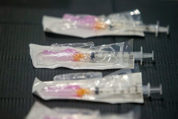 Syringes wait on table to be filled with COVID-19 vaccine. A highly transmissible variant of the coronavirus first identified in the United Kingdom has been detected in a woman from the Philadelphia area, officials announced Friday. It is still susceptible to the vaccine.