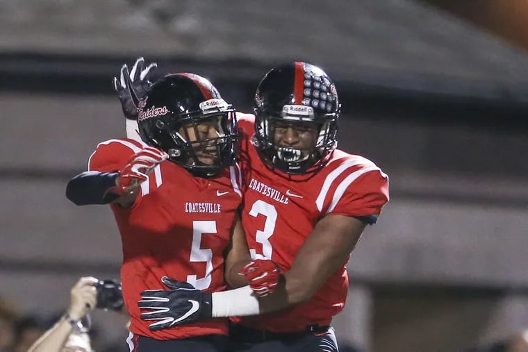 Coatesville's Dymere Miller (5) celebrates his touchdown catch in a 42-14 win over Downingtown West with teammate Tione Holmes (3).