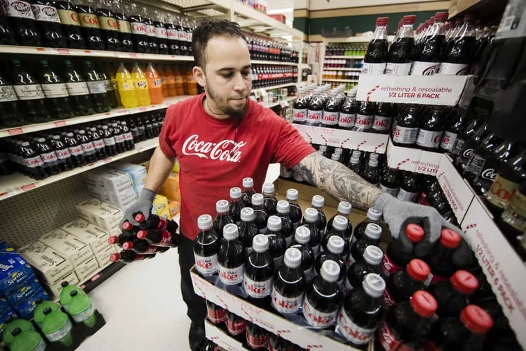 Albert Delarosa stocks shelves with Coca-Cola products at the IGA supermarket in Port Richmond.   (AP Photo/Matt Rourke)