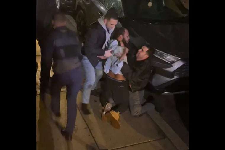 A still image from a video showing South Task Force officers Robert Cucinelli and Alexander Camacho (kneeling) handcuffing Damarcus Tucker.