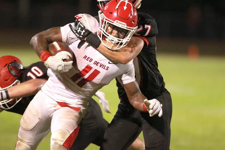 Iverson Clement of Rancocas Valley drives for extra yards as Jake Topolski, right, of Lenape struggles to bring him down in the 2nd half at Lenape on Oct. 6, 2017. CHARLES FOX / Staff Photographer