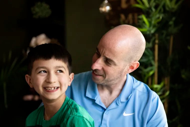 Liam Reed, 8, and Jason Reed at their home in Cherry Hill, N.J. They will walk across the stage at Rutgers-Camden's commencement on Monday to receive Sunny Reed's doctoral degree. Sunny Reed was Liam's mother and Jason's wife. She died of cancer in March.