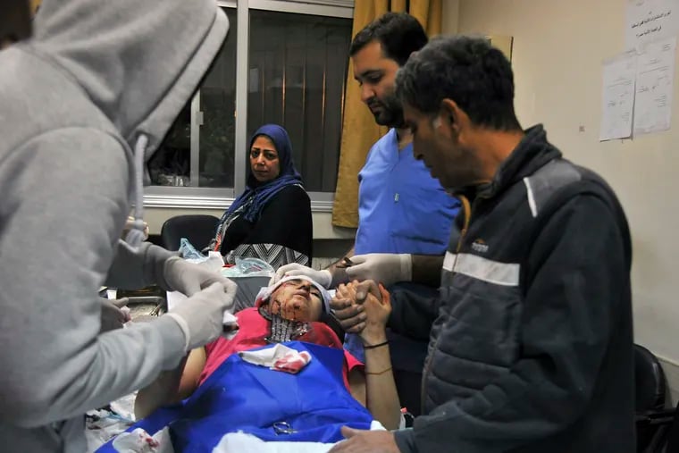 In this photo released by the Syrian official news agency SANA, a paramedic treats an injured woman wounded by Israeli missile strikes at a hospital in Damascus, Syria, Wednesday, Nov. 20, 2019. The Israeli military on Wednesday said it struck dozens of Iranian targets in Syria, carrying out a "wide-scale" strike in response to rocket fire on the Israeli-controlled Golan Heights the day before.