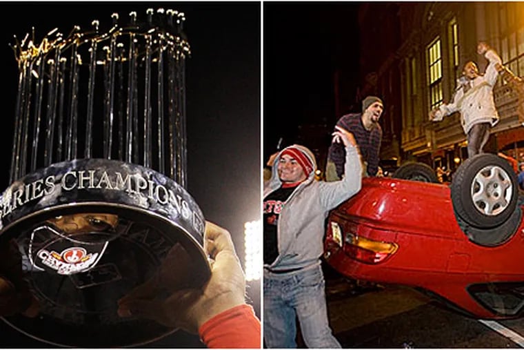 Ryan Howard, left, holds up World Series Champions trophy last night, as fans, right, took to the streets and celebrated to an overturned car on Walnut Street near Broad Street. (AP / Jessica Griffin / Staff Photographer)