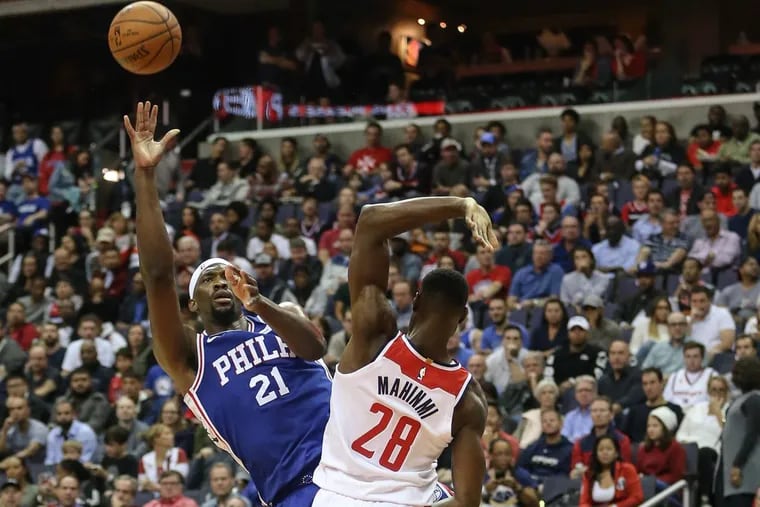 Sixers center Joel Embiid shoots over Wizards’ Ian Mahinmi during the first quarter at the Capital One Arena in Washington, DC on Wednesday.