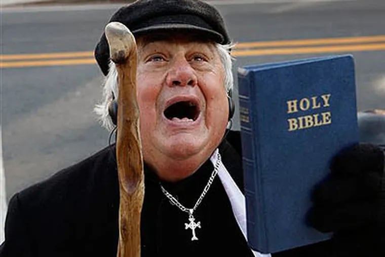 Rev. Martin P. Lombardo, of Princeton, N.J., shouts against gay marriage as he holds a Bible outside the New Jersey Statehouse Thursday. (AP Photo / Mel Evans)