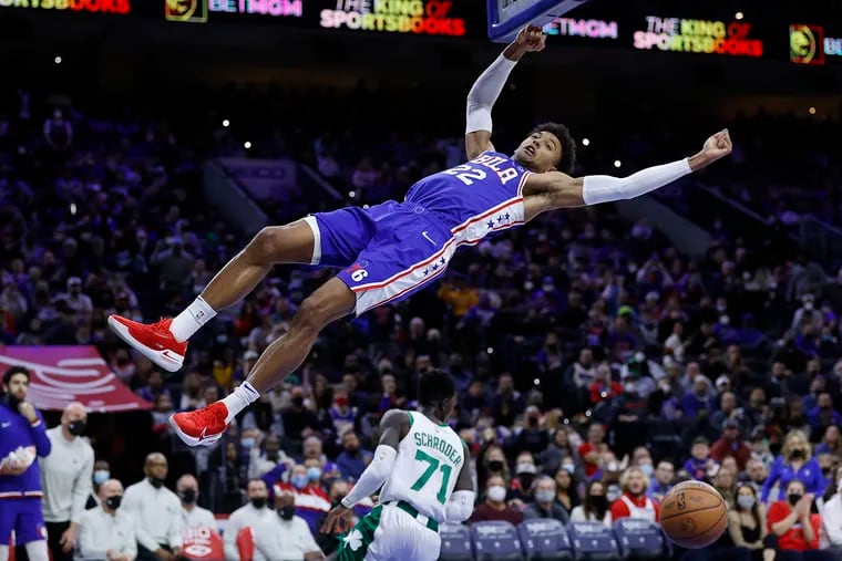 Sixers guard Matisse Thybulle falls down after dunking the basketball after getting fouled by Boston Celtics guard Dennis Schroder in the third quarter on Jan. 14 in Philadelphia.