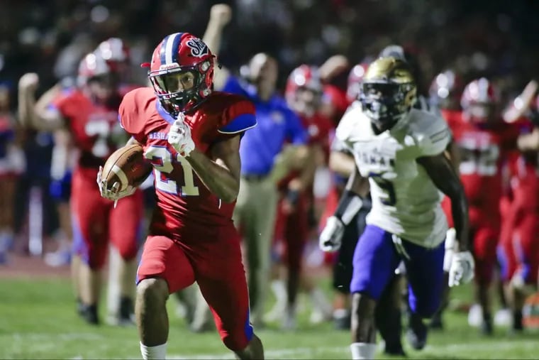 Neshaminy’s Marcus Griffin (left) returns an interception in the third quarter for a touchdown on Friday.