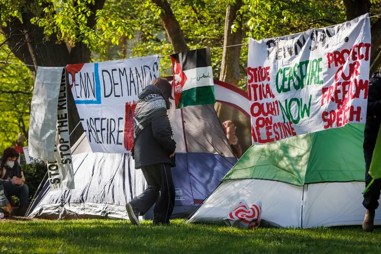 Participants in a pro-Palestinian demonstration on the University of Pennsylvania's campus display signs near their tents Friday.