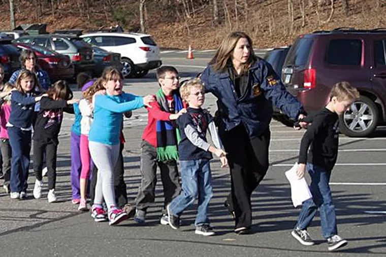 State police usher children away from Sandy Hook Elementary School in Newtown, Conn., after the shooting. SHANNON HICKS / Newtown Bee