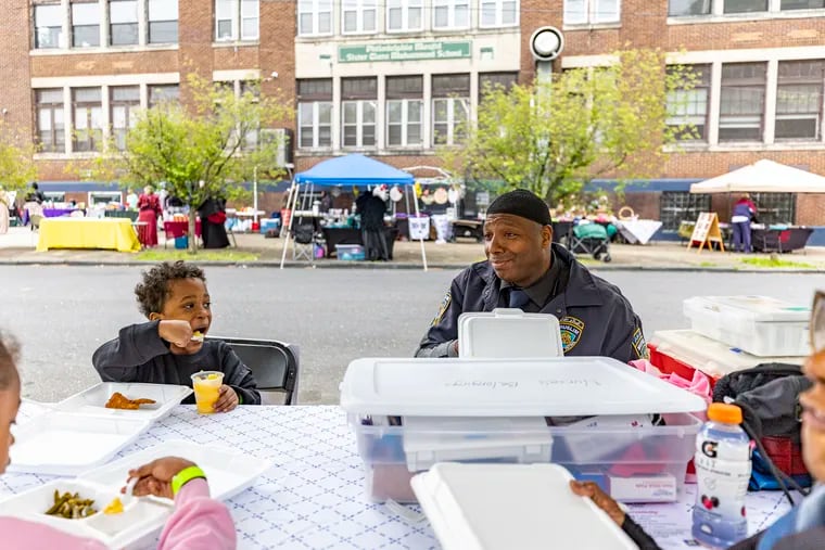 Isha Isa, an EMT with the New York City Fire Department, shares a meal with Waheedah Salaam, a retired Temple nurse, and her grandkids Anum Salaam, 7, and Ari Salaam, 5, of North Philadelphia, during the Philadelphia Masjid community event at the Clara Muhammad Square on April 27.