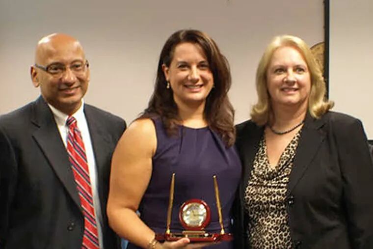At the Board of Education meeting announcing Burlco's Jeanne DelColle, center, as N.J. Teacher of the Year, she is joined by board president Arcelio Aponte, left, and her mother.