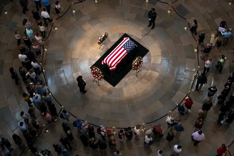 Members of the public walk past the flag-draped casket bearing the remains of John McCain of Arizona, who lived and worked in Congress over four decades, in the U.S. Capitol rotunda in Washington, Friday, Aug. 31, 2018. McCain was a six-term senator from Arizona, a former Republican nominee for president, and a Navy pilot who served in Vietnam where he endured five-and-a-half years as a prisoner of war. He died Aug. 25 from brain cancer at age 81.