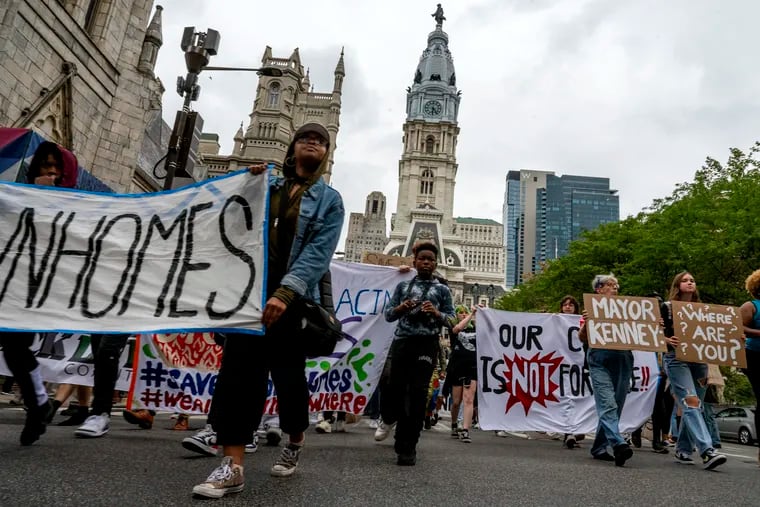 Protesters and residents of the UC Townhomes affordable housing complex march north on Broad Street after a rally outside City Hall on Wednesday. They are being evicted Oct. 8.